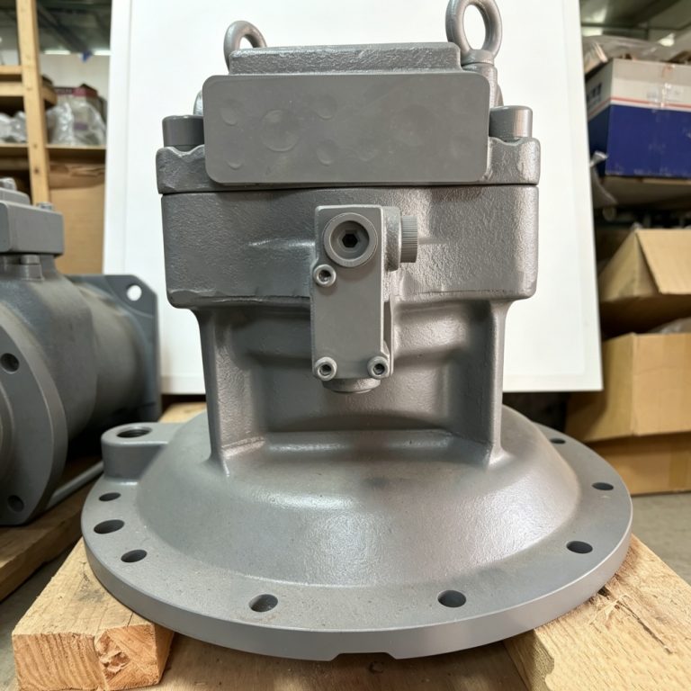 Gray excavator hydraulic swing motor with circular mounting flange, valve block and capped ports