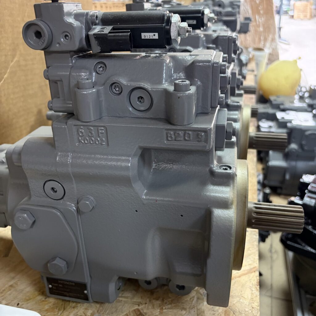 Remanufactured Hitachi YA00006715 fan pump with solenoid and regulator, photographed on a workshop pallet